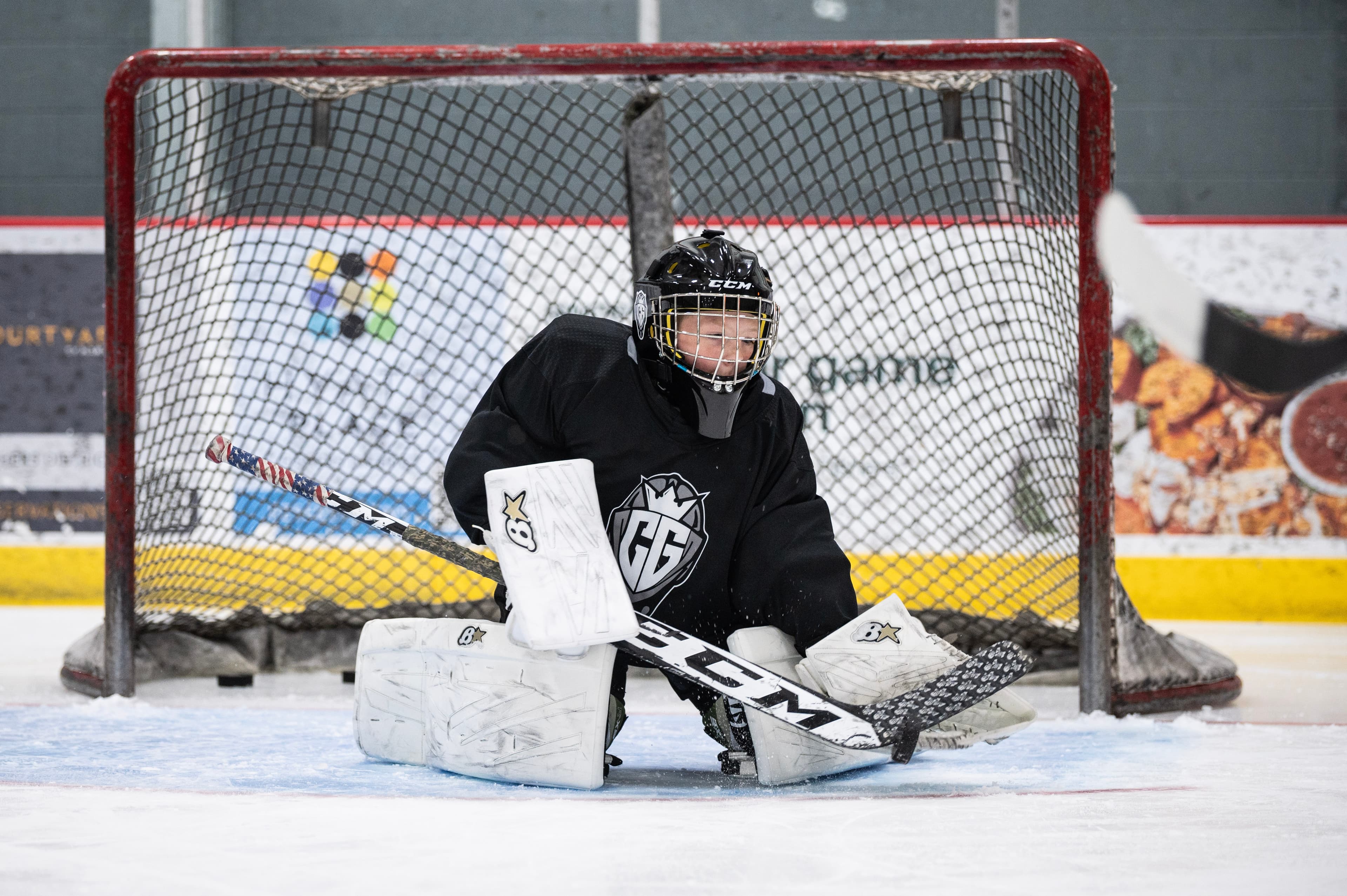 Young goalie in net, looking directly at camera