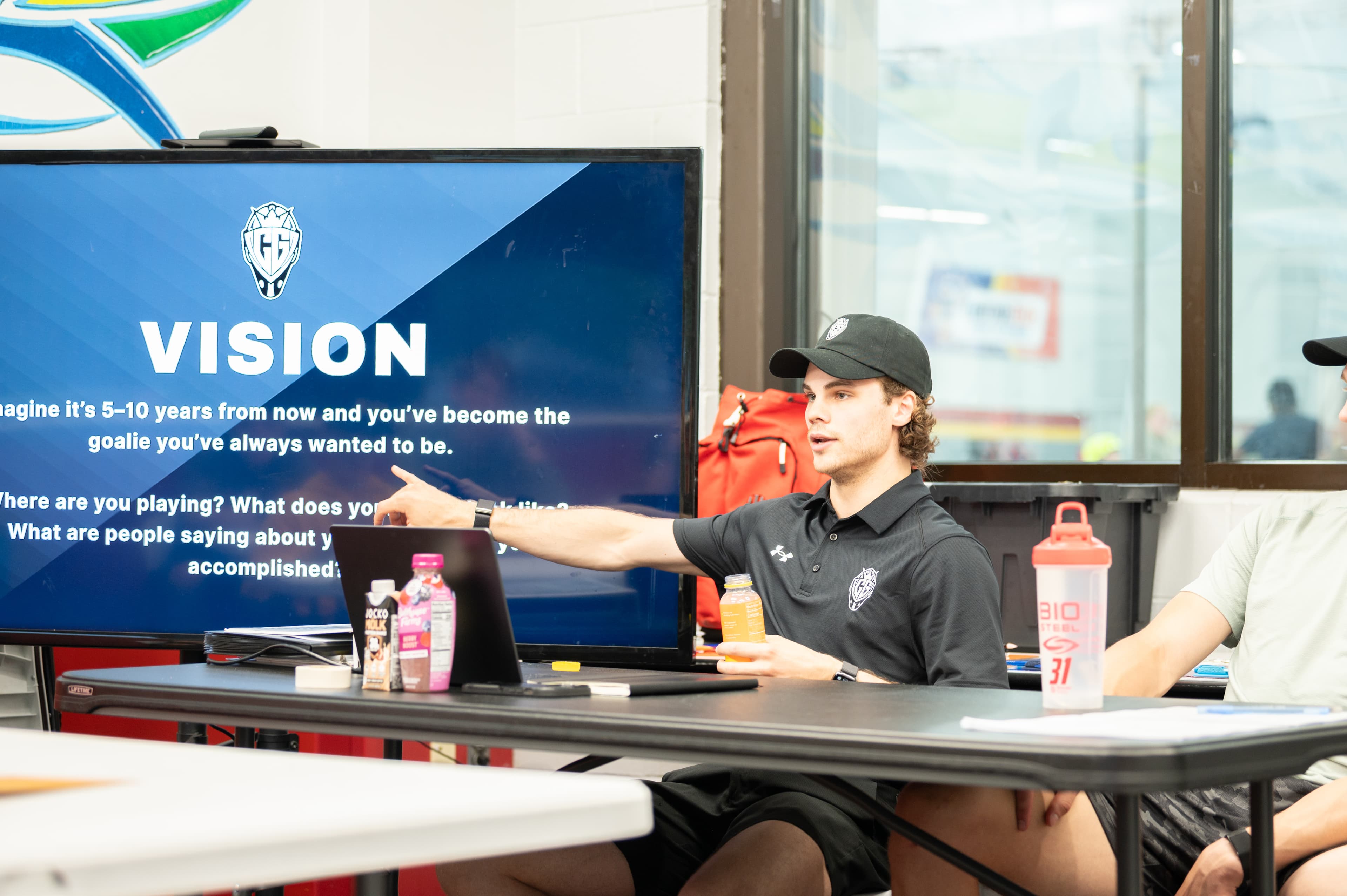 Cam Gray pointing to a vision exercise on a classroom screen during a CGG session.