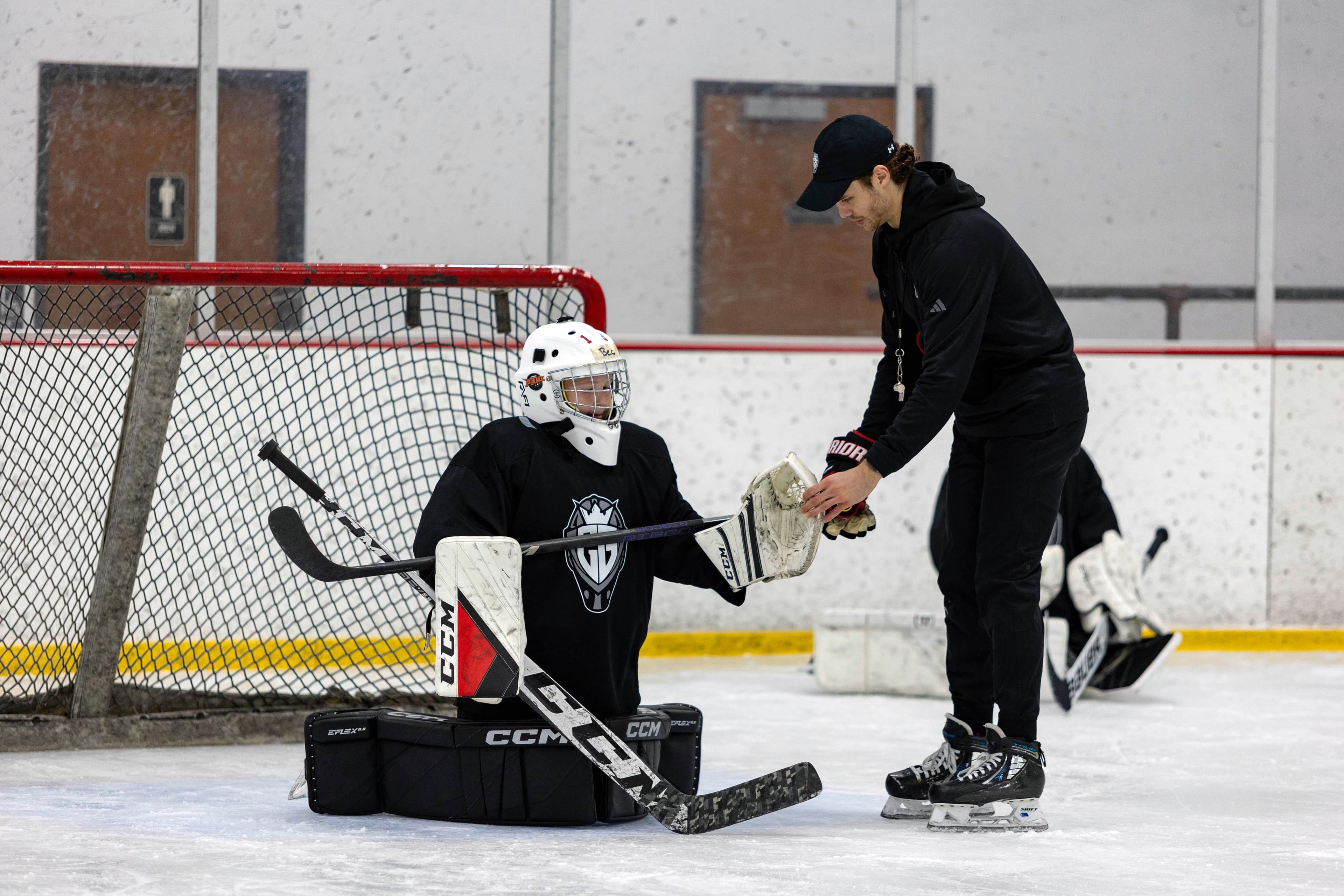Cam Gray coaching a young goalie in the net
