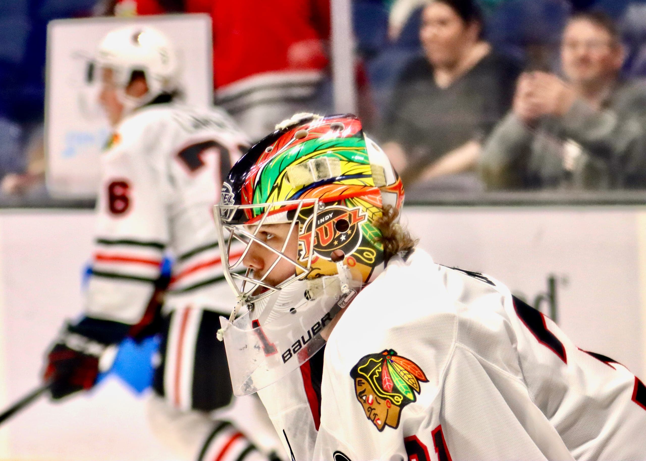 Cam Gray in Chicago Blackhawks organization colors, looking down the ice.